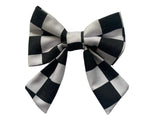 A black and white checkered bow tie designed for dogs, displayed on a plain background.