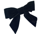 A large black velvet hair bow with a silver-colored barrette clip attached for fitting, displayed on a white background.