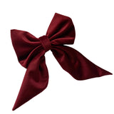 Oversize burgundy red, long tail velvet clip on hair bow on item background