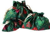 Reusable green Christmas gift bags with a tree design, displayed in three different sizes.
