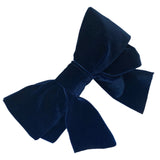A navy blue velvet hair bow clip with a silver-colored barrette clip attached, displayed on a white background.