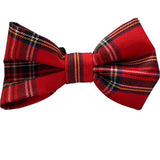 A red tartan dog bow tie displayed on a white surface.