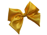 A yellow satin hair bow clip displayed on a white background, with a silver-colored barrette clip attached.