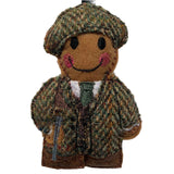 A handcrafted felt gingerbread man ornament in a traditional tweed outfit, with a smile on its face, designed as a hunter/gamekeeper.