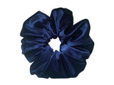A navy blue velvet hair scrunchie on white background.