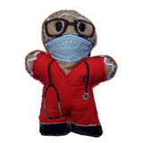 Felt gingerbread decoration wearing a red scrubs, face mask, and glasses on a white background