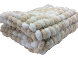 Pram baby blanket cover in neutral shades of beige and white. This chunky knit baby blanket cover is hand knitted in a super soft  pom pom wool.
