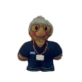 Nurse gingerbread man decoration wearing glasses and navy scrubs on a white background