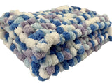 Pram baby blanket in shades of blue and white. This chunky knit baby blanket cover is hand knitted in a super soft  pom pom wool.