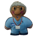 Nurse gingerbread decoration wearing blue scrubs with a name tag on a white background