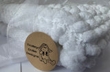 Baby blanket in white. This chunky knit baby blanket is hand knitted in a super soft  pom pom wool.