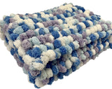 Pom pom blanket knitted.