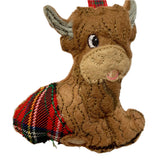 A felt decoration in the shape of an  highland cow with a red tartan kilt.