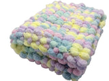 Pram baby blanket in pastel colours. This chunky knit baby blanket cover is hand knitted in a super soft  pom pom wool.