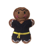 Felt gingerbread man figurine wearing a black martial arts uniform with a yellow belt on a white background.