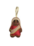 Decorative ornament of a woman in a red saree with a gold ribbon on a white background