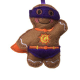 Felt gingerbread man superhero ornament with cape and mask on a white background
