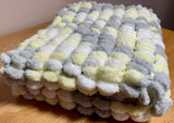 Pom pom blanket knitted.