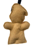 Back view of a gingerbread man soldier decoration, photographed against a plain white background.