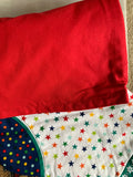 A close up of a folded  handmade Christmas stocking showing the red fabric back, 