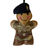 Fabric ornament of a person in military uniform with a beret on a white background