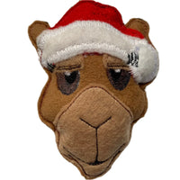 A felt camel Christmas decoration wearing a red and white Santa hat.