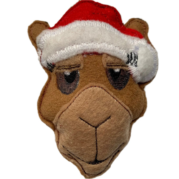 A felt camel Christmas decoration wearing a red and white Santa hat.