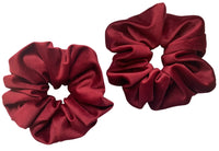 Two maroon scrunchies on a white background