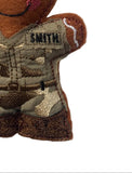 Close-up of a handmade embroidered fabric gingerbread person ornament wearing a desert camouflage uniform with a name patch reading 'SMITH'.