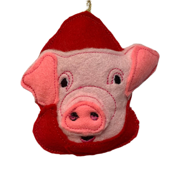 Felt pig Christmas decoration with red outfit on a white background