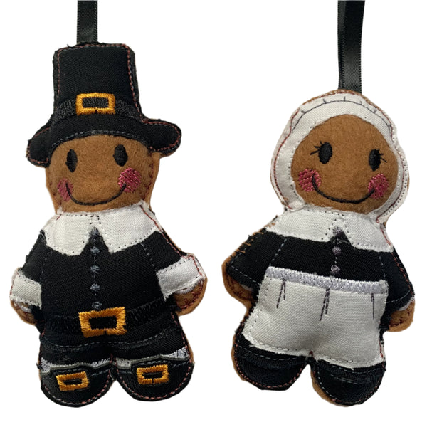 Pilgrim father's gingerbread decorations, in male and female dress, on a white background. 