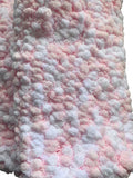 Close-up of a pink and white textured baby blanket