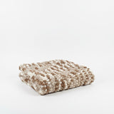 Textured brown and white blanket on a white background..