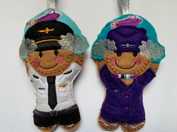 Pilot and cabin crew felt gingerbread decorations with clouds and airplane.