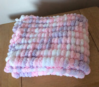 Pom pom blanket knitted.