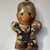 Gingerbread soldier felt decoration with gun.  in MTP machine embroidered fabric uniform and helmet and faux leather boots. Lightly filled and hand finished to create depth and character.