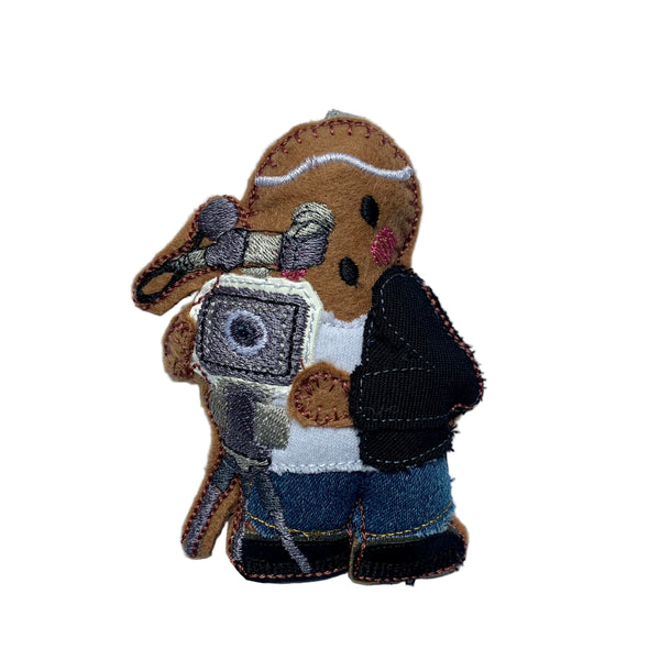 A gingerbread man decoration with a camera, designed as a wedding photographer/videographer, primarily in brown and black colors.