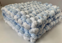 Pom pom pram blanket knitted.