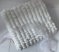 Pom pom blanket knitted.