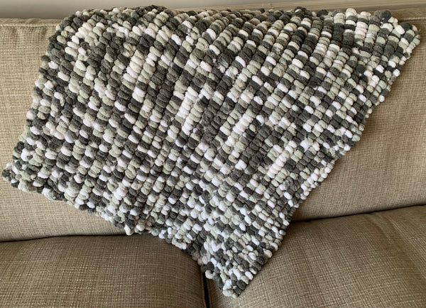 Large grey, graphite and white hand knitted pom pom wool baby blanket.