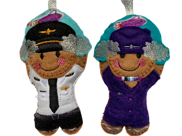 Pilot and cabin crew felt gingerbread decorations with clouds and airplane. On white background.