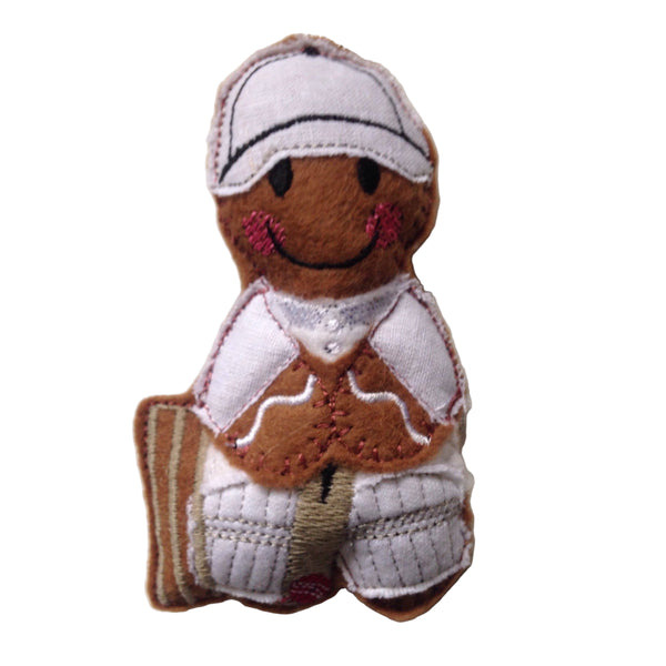 Gingerbread man cricketer wearing cricket whites and cap and holding a cricket bat, intended as a Christmas decoration.