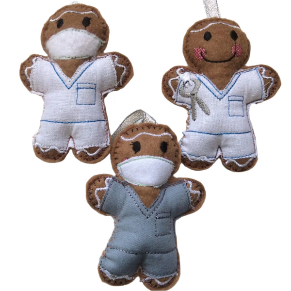 Three gingerbread man decorations in dentist and dental nurse themed outfits, made of felt and designed as Christmas ornaments.