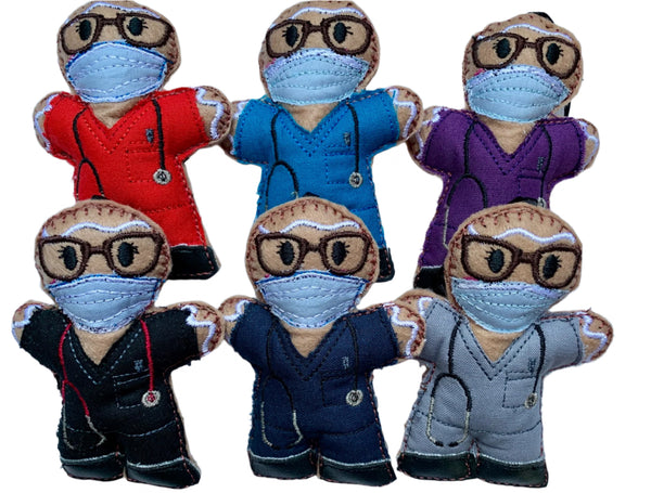 Set of felt  gingerbread Christmas decorations dressed in medical scrubs with face masks and glasses. On a white background
