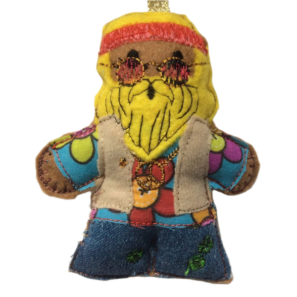 A felt gingerbread man decoration with a colorful hippie-themed outfit, sunglasses, and a beard, designed as a Christmas tree ornament. On white background.