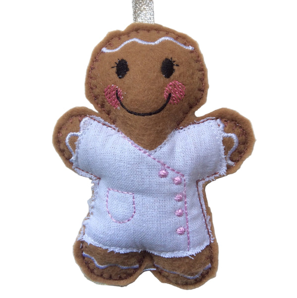Beautician felt gingerbread decoration. Dressed in white cotton tunic with baby pink buttons and decorative finish. Lightly filled with a polyester filling to create depth and character. Hand sewn to finish.