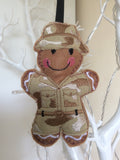 Soldier felt gingerbread decoration. Dressed in a cotton fabric embroidered camouflage uniform and sun hat Lightly filled to create depth and character.