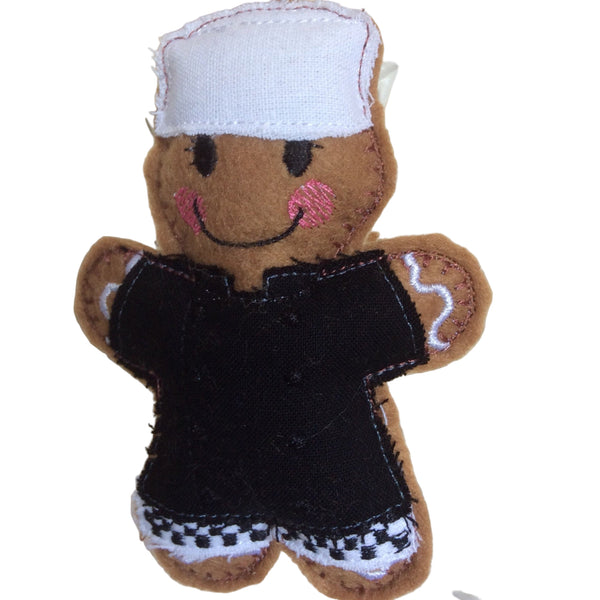 Chef in black uniform and white hat, gingerbread man decoration.