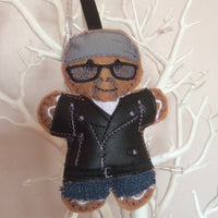 Biker gingerbread man decoration. With grey cotton headscarf, white cotton t shirt, jeans and black faux leather bikers jacket. Lightly filled with a polyester stuffing to create depth and character. Hand sewn to finish