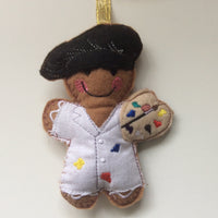 Artist felt gingerbread decoration. Dressed in a  fabric smock, felt hat, with paint pallette and brush with a polyester stuffing. Hand sewn to finish.